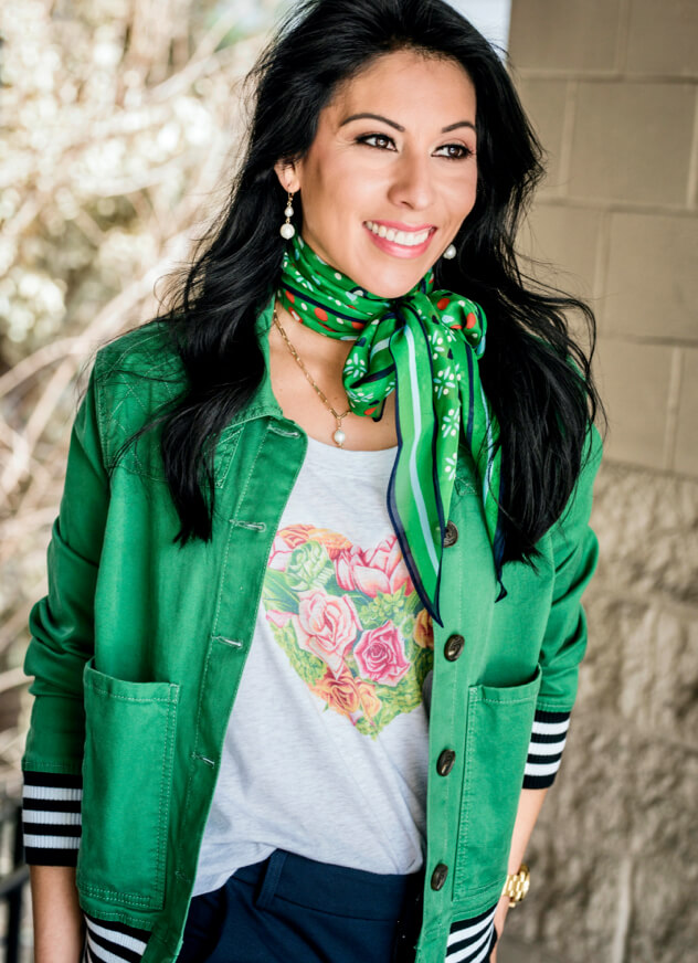 Female model wearing the cabi Botanical Tee in Heather Grey, Mod Bomber in Grass, and the Pencil Trouser in Classic Navy