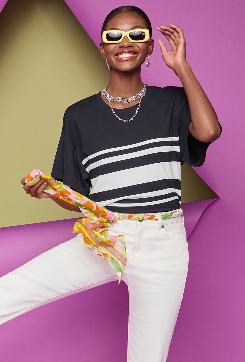 Model Wearing Catamaran Tee in Classic Navy and White Stripe, 5th Avenue Jean in White, Romance Scarf in Floating Flowers, Collar Necklace in Silver, Timepiece Earrings in Silver and Gold.